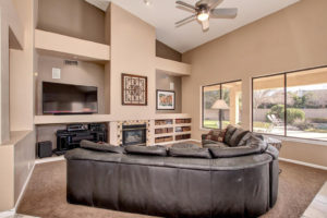 Family room with shelvin and windows to the back of the house