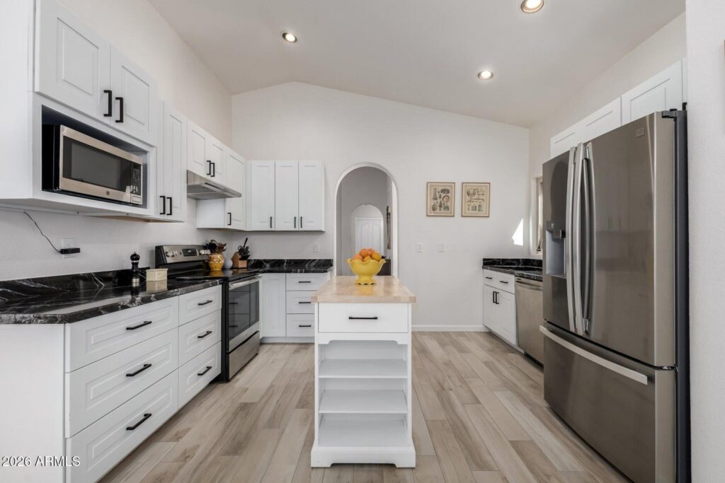 Remodeled kitchen in Sun Lakes AZ home with granite countertops shaker cabinets and stainless steel appliances